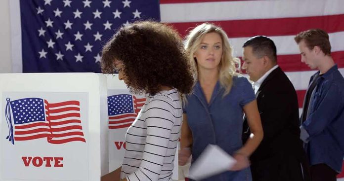 Voters at polling booths in front of an American flag