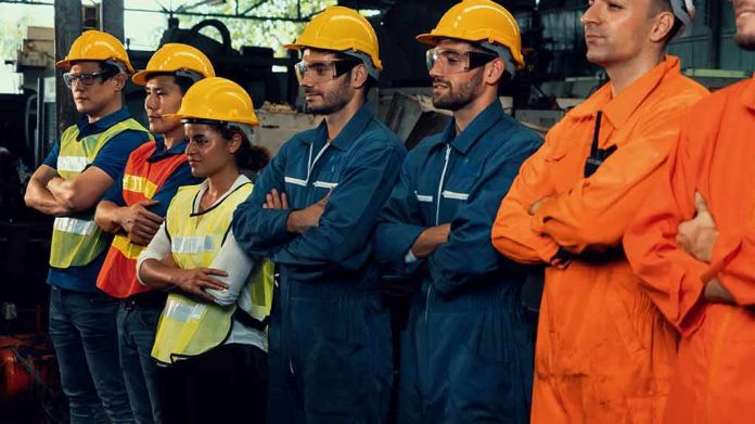 shutterstock_1905872197-1 Industrial workers standing together in safety gear