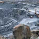 Trump’s Critical Mining Power Play Open-pit mine with haul trucks and excavators on terraced roads