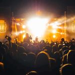 Crowd at a nighttime concert with bright stage lights