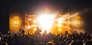 Crowd at a nighttime concert with bright stage lights