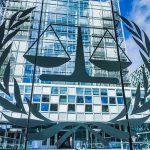 Scales of justice emblem on glass facade of modern office building