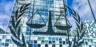 Scales of justice emblem on glass facade of modern office building