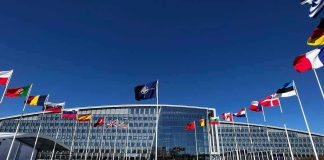 Is America’s Era of Global Dominance ENDING? NATO headquarters with member flags in front under a clear blue sky