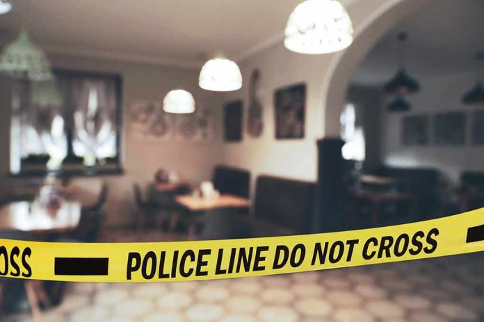 shutterstock_2348477649 Police tape blocks entrance to a dimly lit restaurant interior
