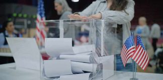 Noncitizen’s 2024 Vote Could Cost Her BIG Person casting a ballot into a clear box at a polling station