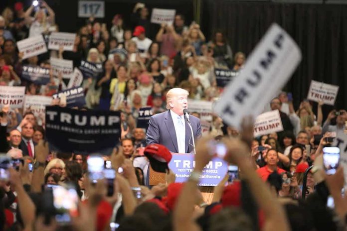man at podium addressing a large crowd at a rally