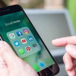 Meta to Pay $567 Million Over Child Harm Hands holding a smartphone with social media apps on screen