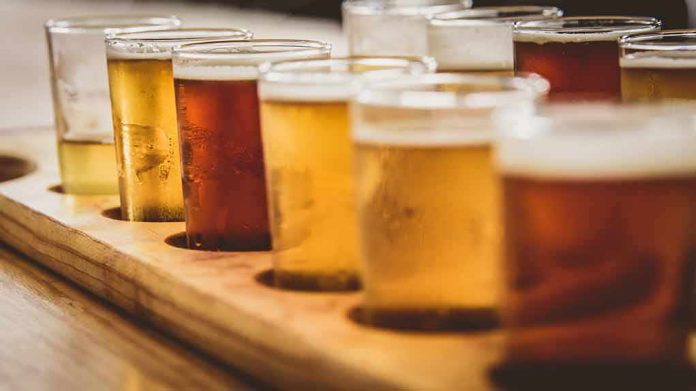 shutterstock_605926250 beer flight with assorted tasting glasses on a wooden tray