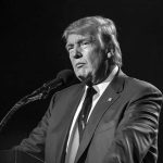 Donald Trump speaking at a microphone in a black-and-white photo