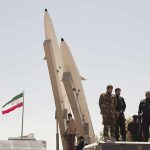 IRGC Fighters Are Being HUNTED Inside Iran Soldiers stand beside large missiles at an outdoor display