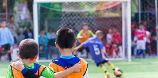 Two boys watching a soccer game together.