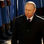 Vladimir Putin walking past a guard of honor