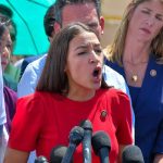 AOC Takes Trans Message Into Catholic Church Judy Chu among crowd as a woman in red speaks at outdoor press event