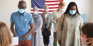 Rust Belt Polls May Be Missing SOMETHING Voters wearing masks stand in line at a polling station