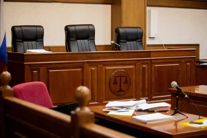 shutterstock_1815414050-1 empty courtroom with judge's bench and microphones