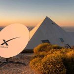Starlink satellite dish near a pyramid-shaped building at sunset
