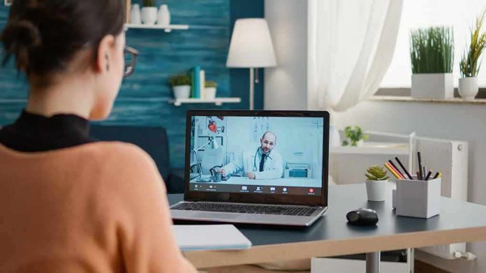 shutterstock_2139345379 Woman on laptop having video call with doctor in home office