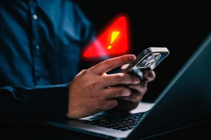 hands holding smartphone with warning alert icon